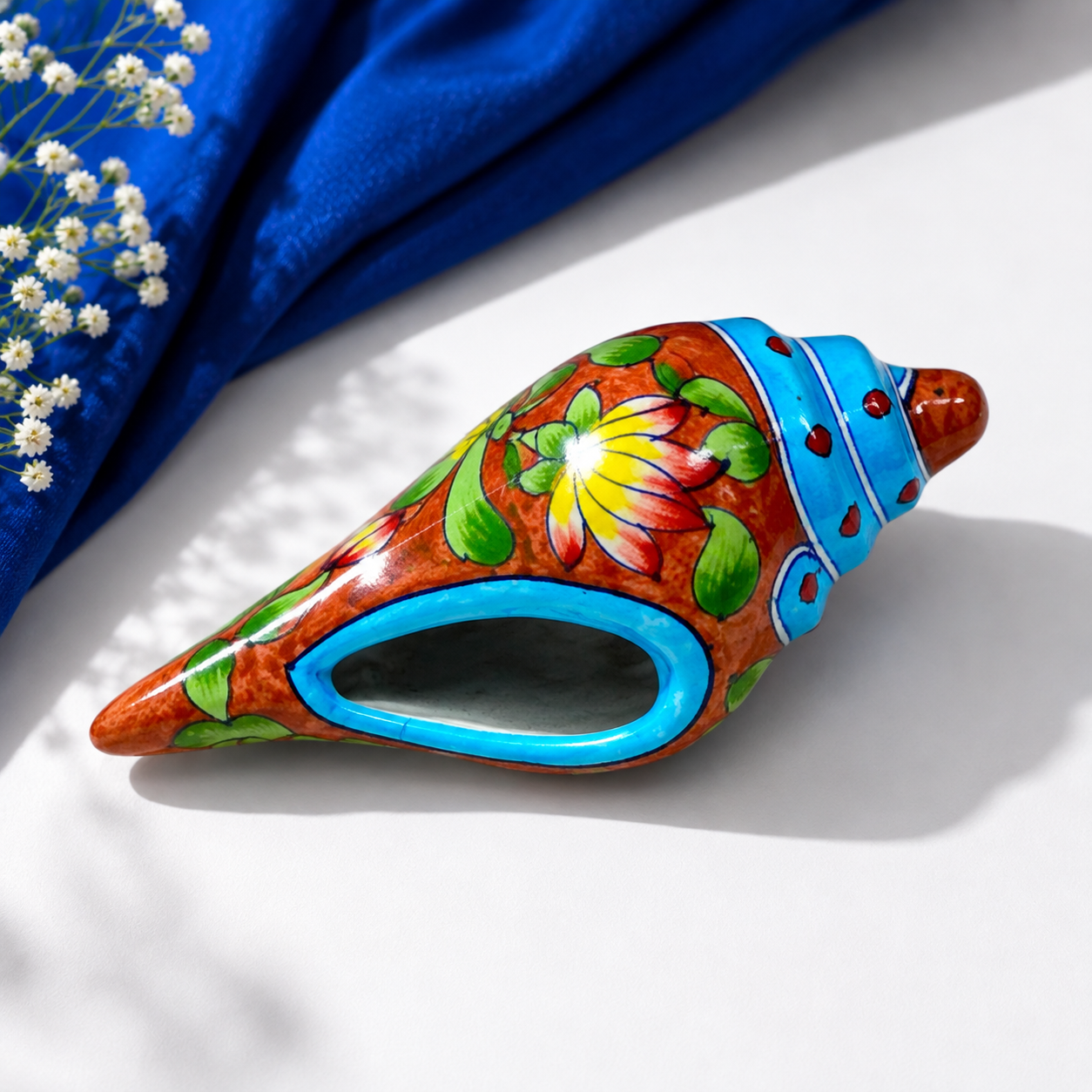 Handpainted yellow lotus floral details on Jaipur blue pottery conch shell by Aditya Blue Art Pottery