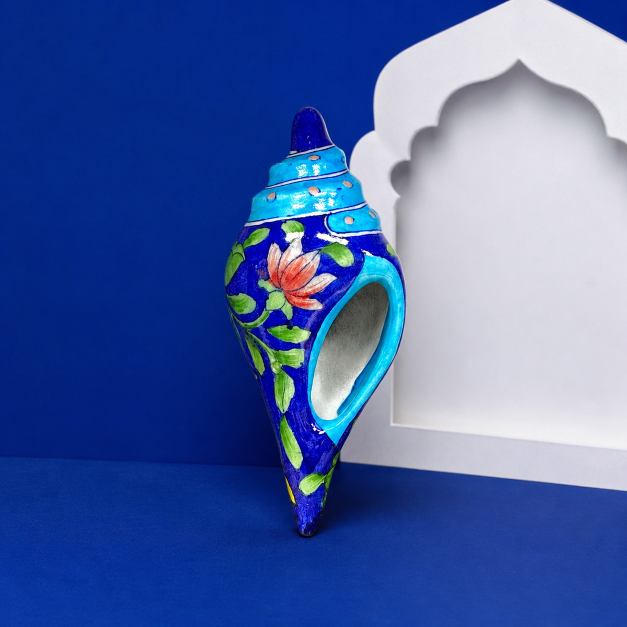 Handpainted yellow lotus floral details on Jaipur blue pottery conch shell by Aditya Blue Art Pottery