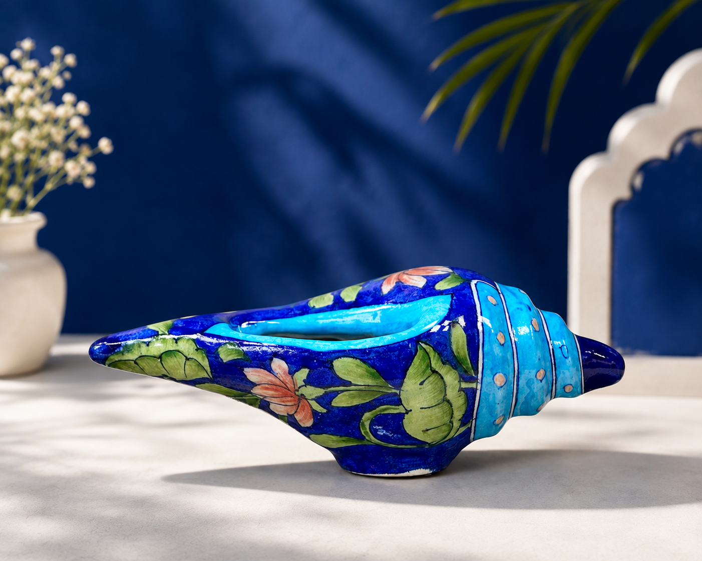 Traditional Jaipur blue pottery decorative shankh with turquoise rim shown in vertical upright display